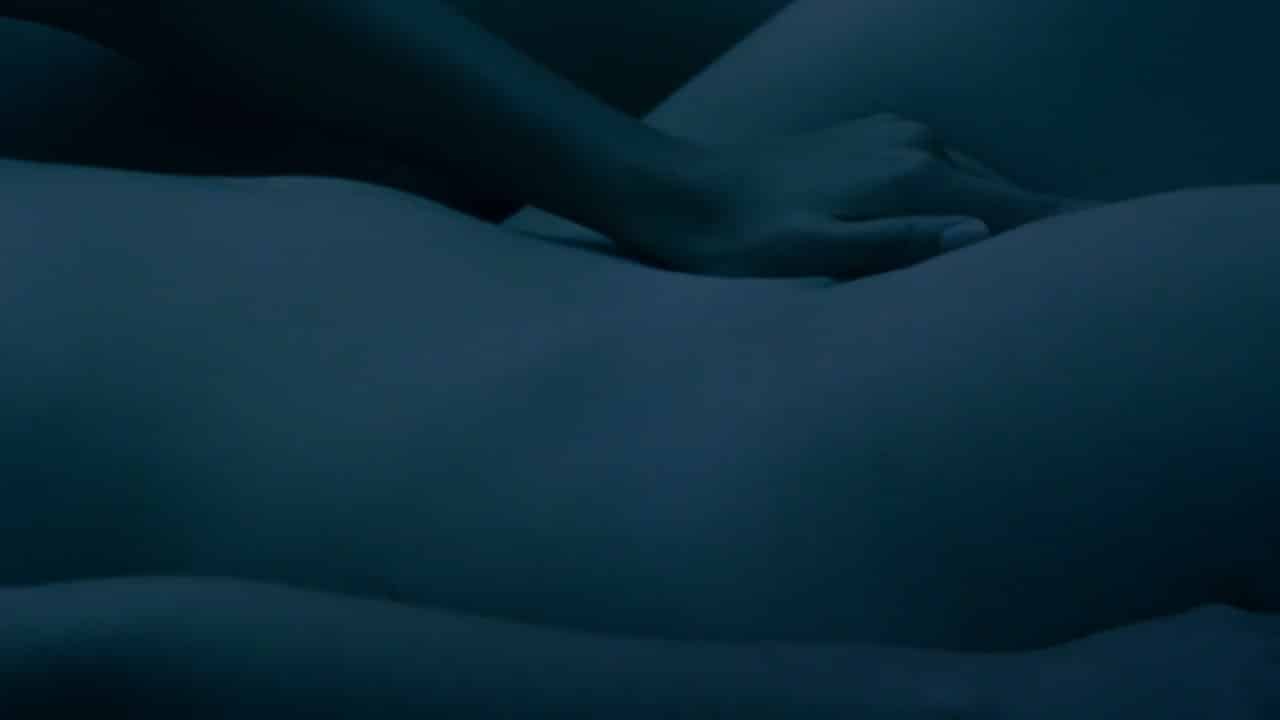 Anna Raadsveld and Charlie Dagelet making out sensually in a bedroom together.