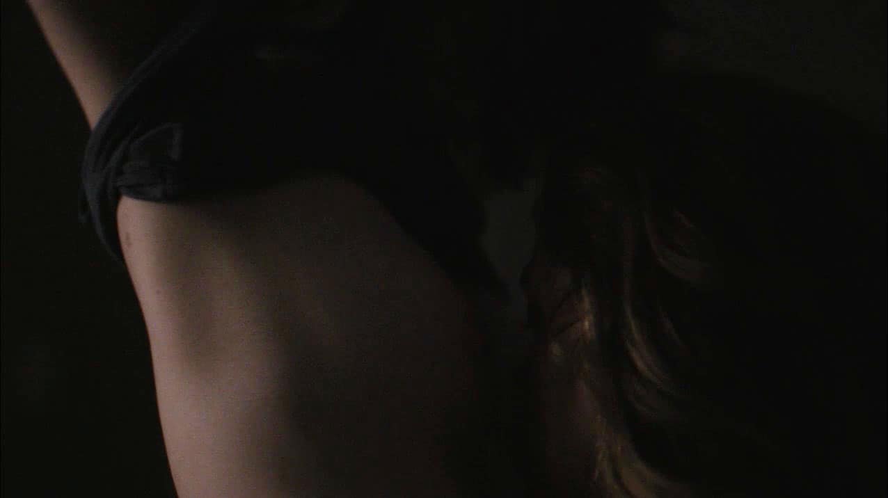 Kate Lyn Sheil leaning over to lesbian kiss Riley Keough in bed