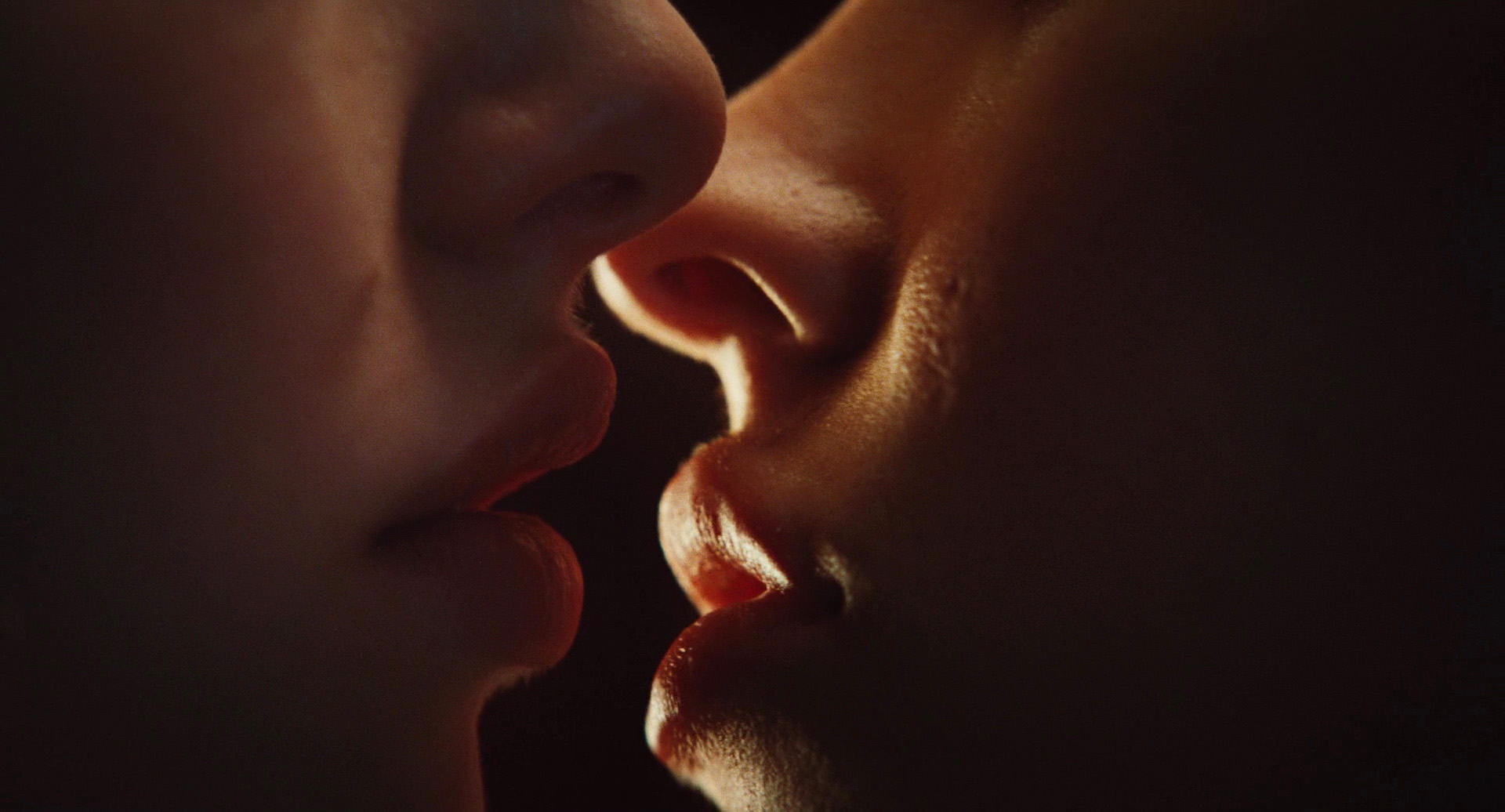 Megan Fox leaning in to passionae lesbian kiss Amanda Seyfried in a bedroom,